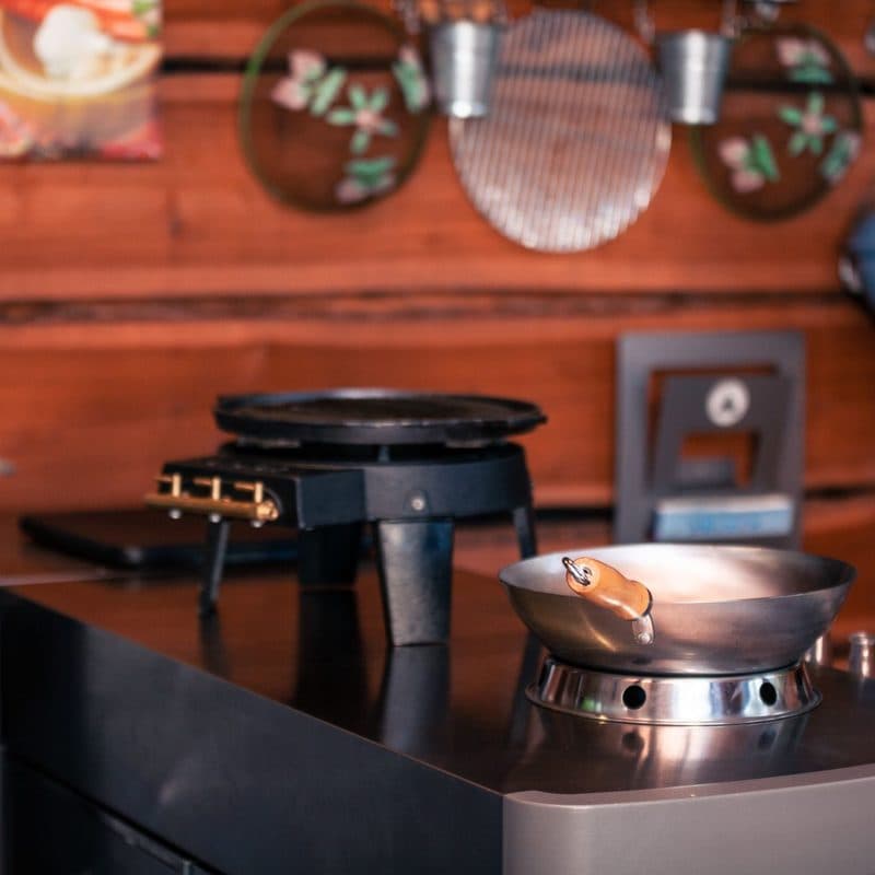 A stainless steel skillet on a burner. Illustrative stock photograph, not a photograph of a specific All-Clad pan.