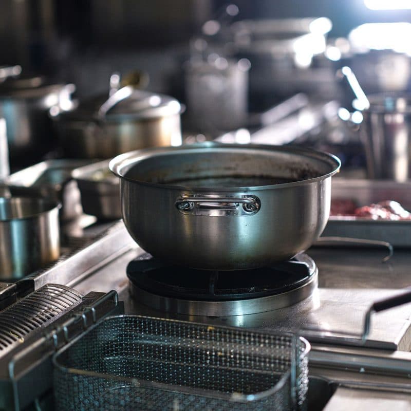 Stainless steel pots on a professional range. Illustrative stock photograph, not a photograph of the reviewed pot.