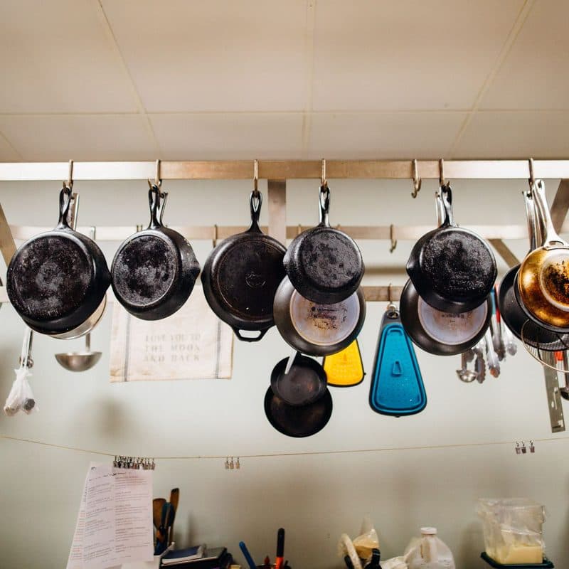 Pans hanging from a rack. Illustrative stock photograph, not a photograph of a specific Heritage Steel pan.