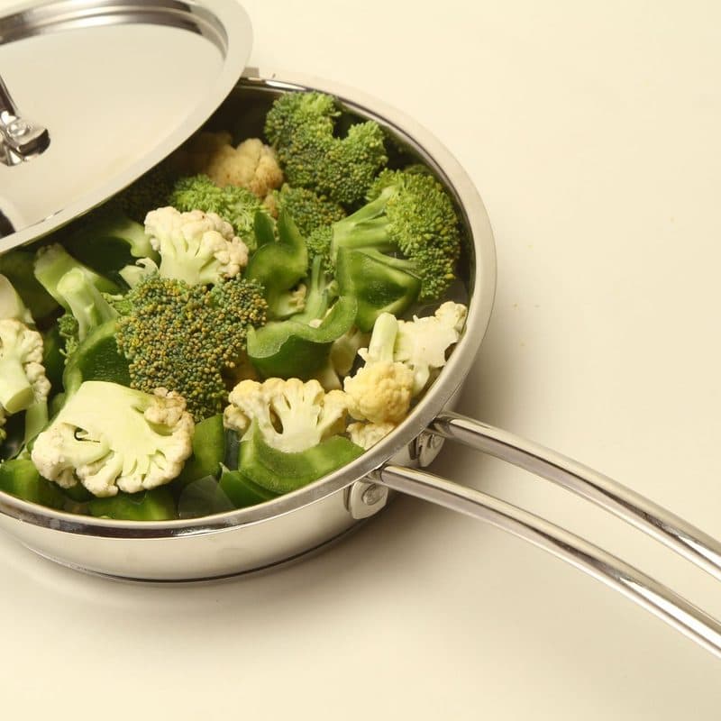 Broccoli and cauliflower cooking in a stainless steel pan. Illustrative stock photograph, not a photograph of the reviewed pan.