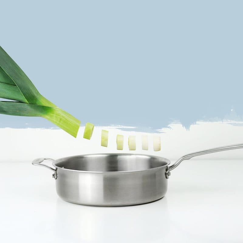 Vegetables cooking in a stainless steel pan. Illustrative stock photograph, not a photograph of a specific Made In pan.