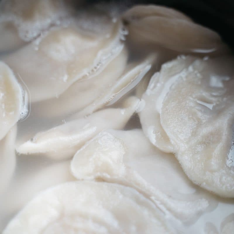 Dumplings cooking in boiling water in a steel pot. Illustrative stock photograph, not a photograph of the reviewed pot.