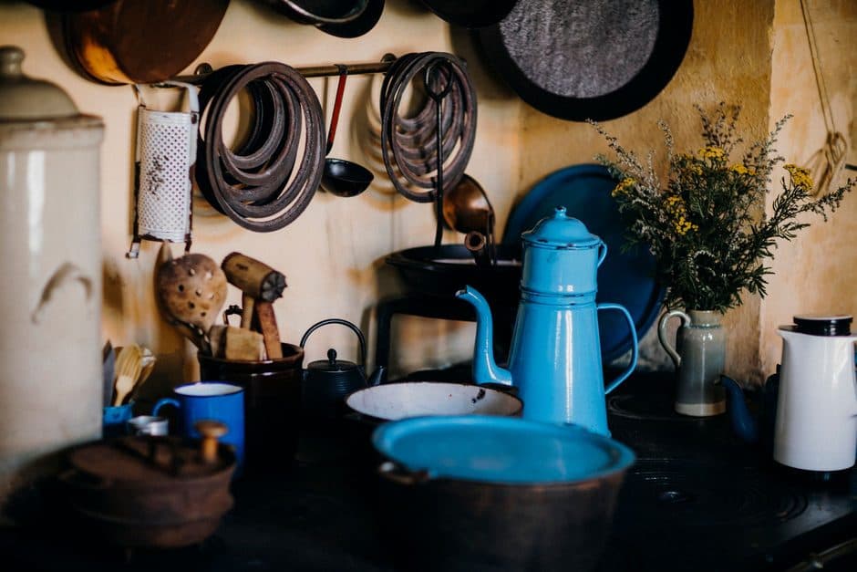 A modest kitchen with a kettle and cooking pots.