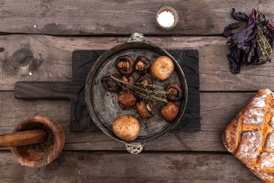 A dark carbon steel pan on a wooden surface.