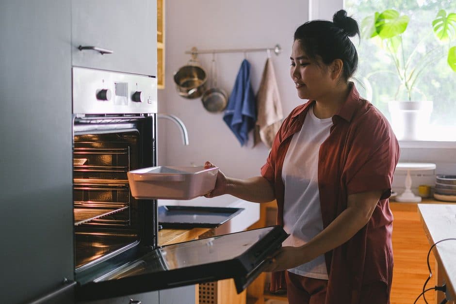 A pan being placed into an oven.