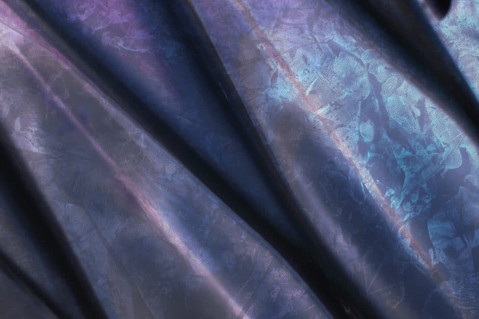 A metallic surface with a faint colored tint.