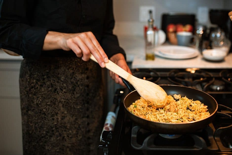 A rice dish being stirred in a pan.