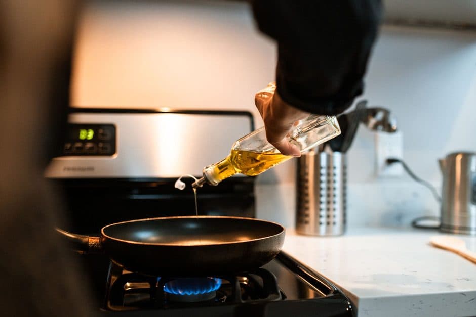 Oil being poured into a hot pan.