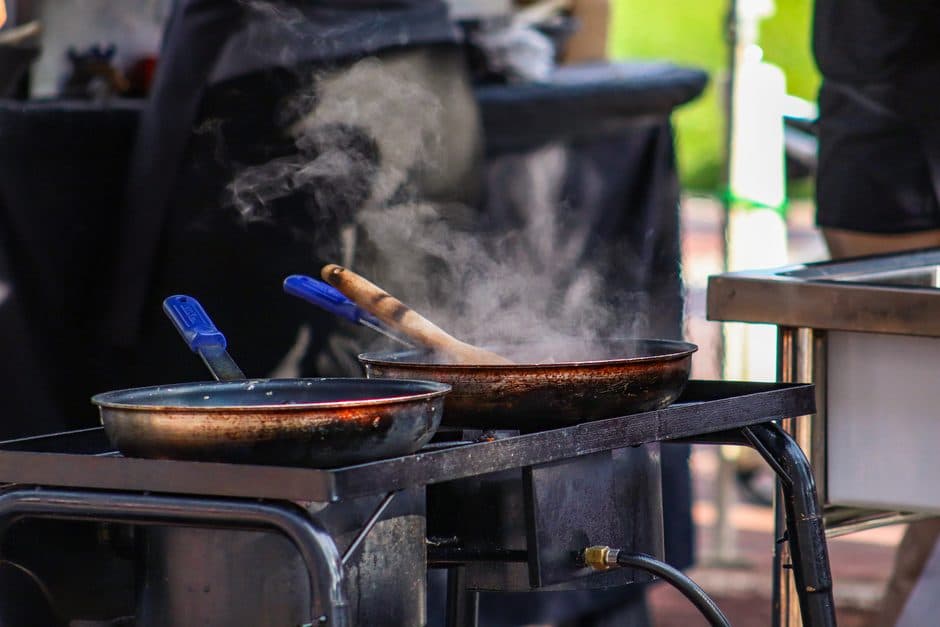 Two frying pans of different sizes on a cooking surface.