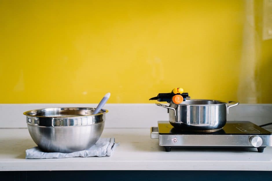 A stainless steel pan and pot on a clean worktop.